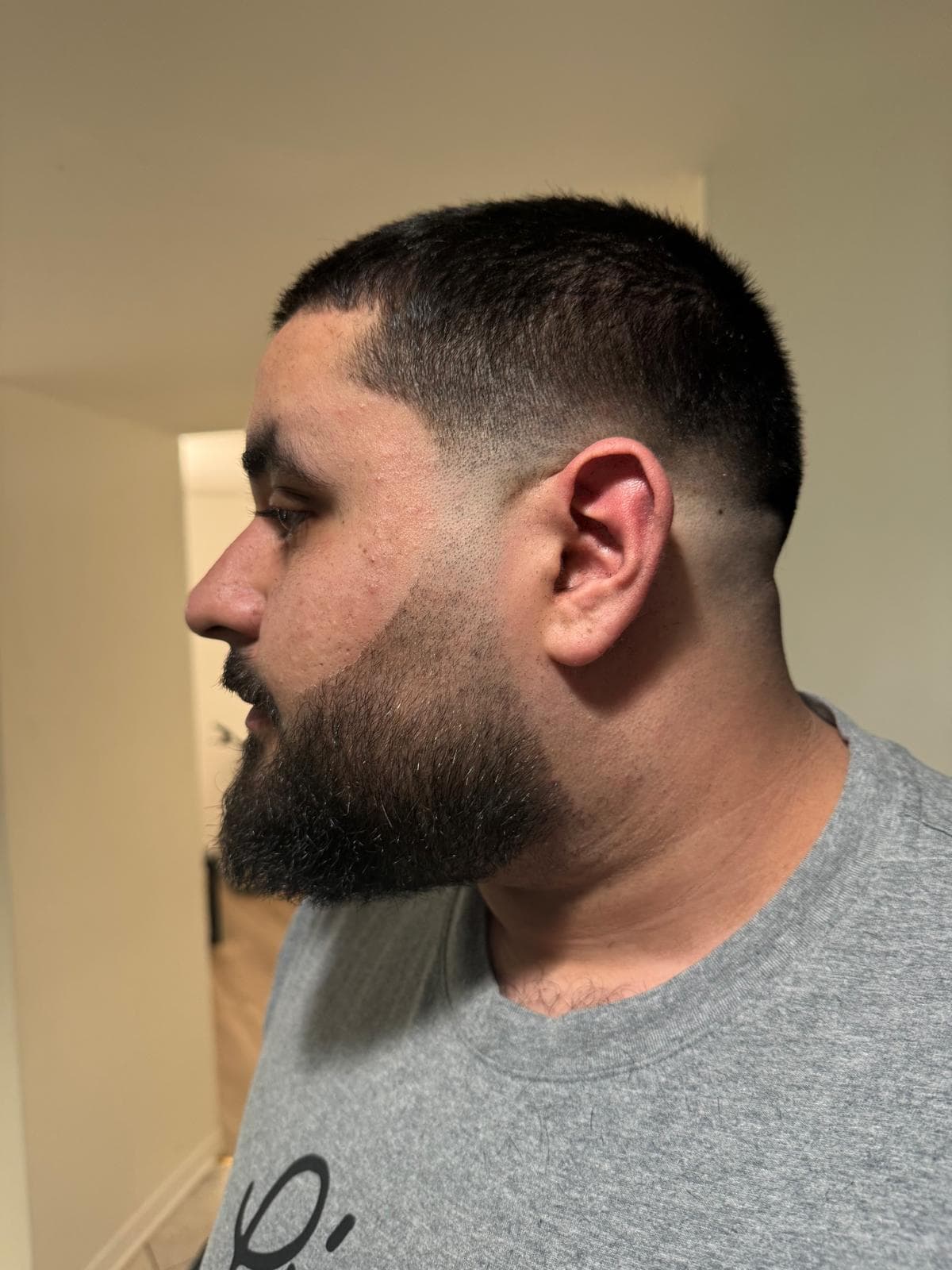Sharp men's buzz cut with clean beard line and side profile finish