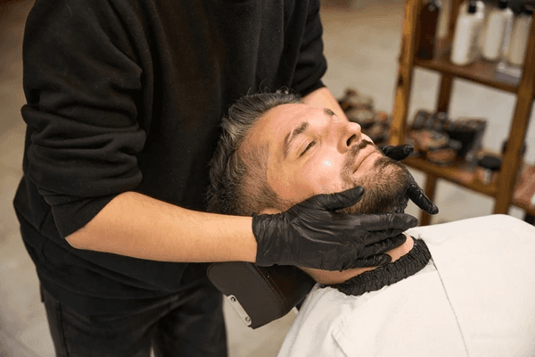 Barber performing precision beard sculpting and full beard shaping service