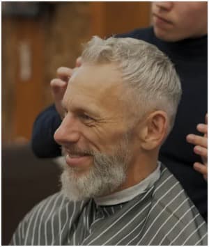 Senior men's haircut and beard grooming service in a comfortable barber setting